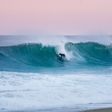 Surfer on a big wave in Hossegor. Pink sky and ocean dream